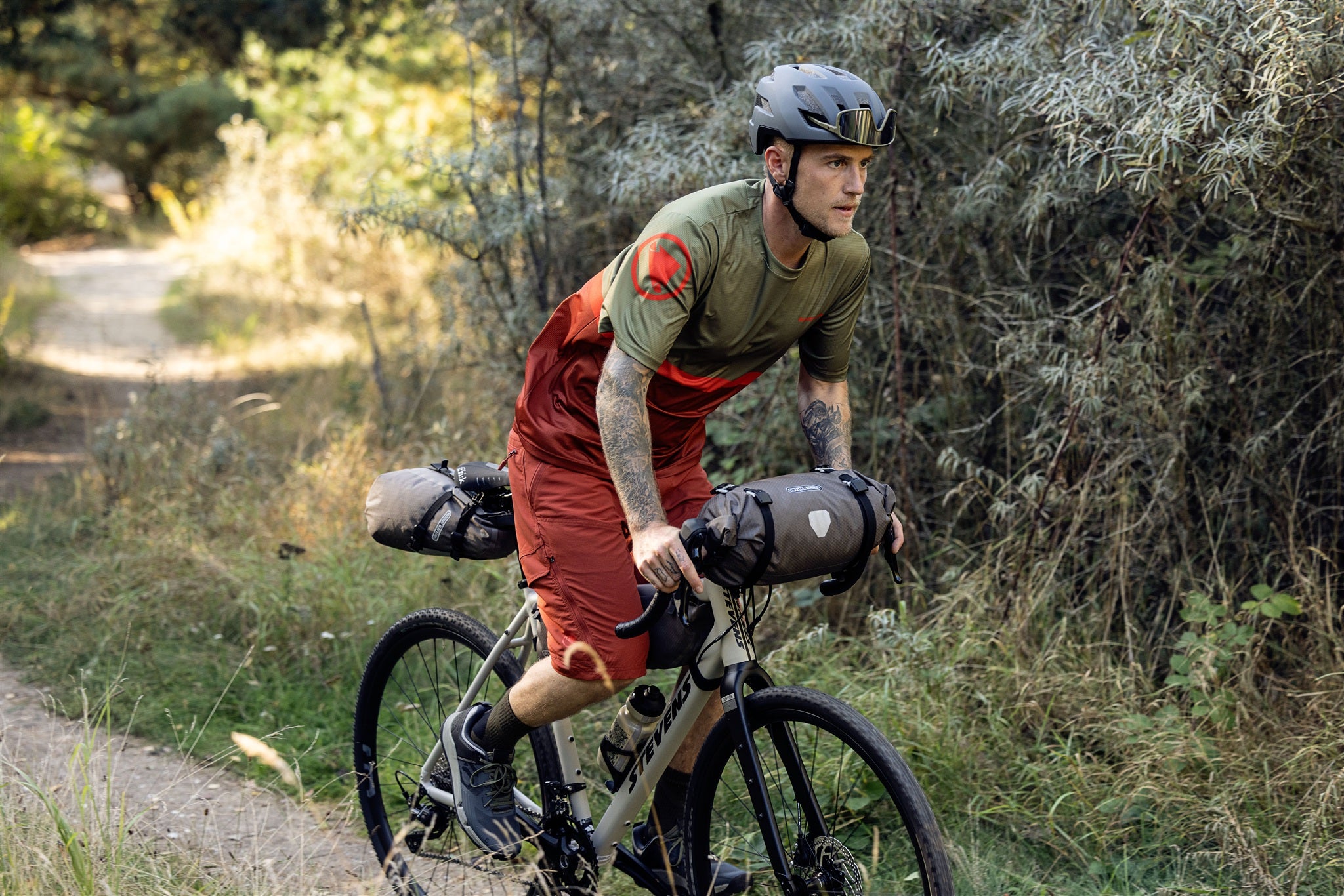 Cycliste fixant le sac de guidon ORTLIEB Handlebar-Pack Flex couleur dark-sand sur un vélo tout-terrain