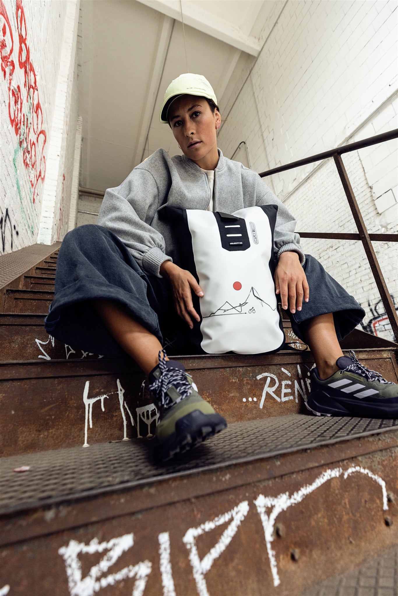 Personne faisant du vélo en ville portant le sac à dos ORTLIEB Velocity Design blanc et noir
